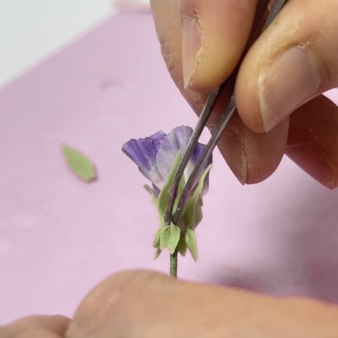 花の根元に萼片をつける手元